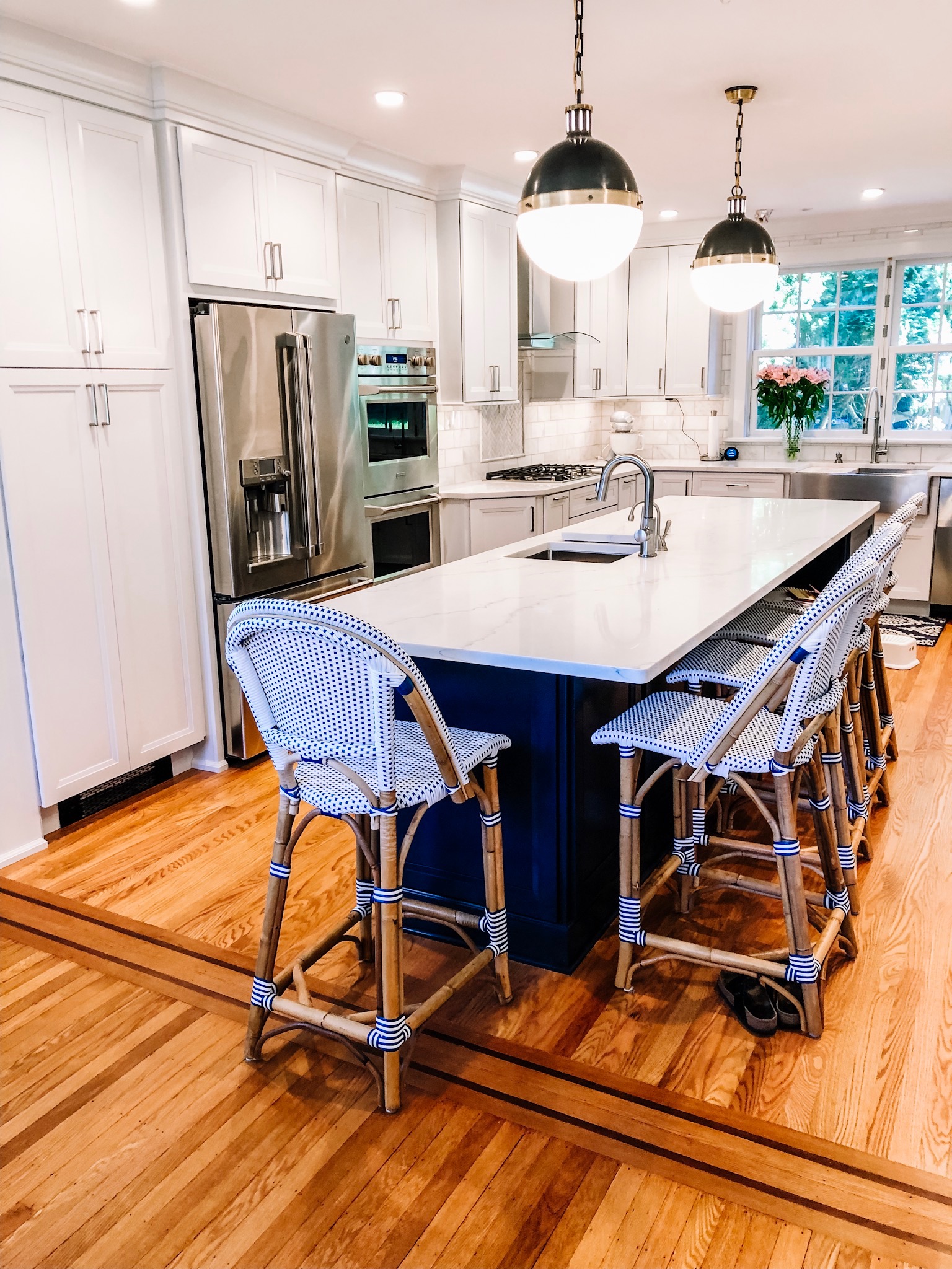 Transitional kitchen with white cabinets and navy blue island.